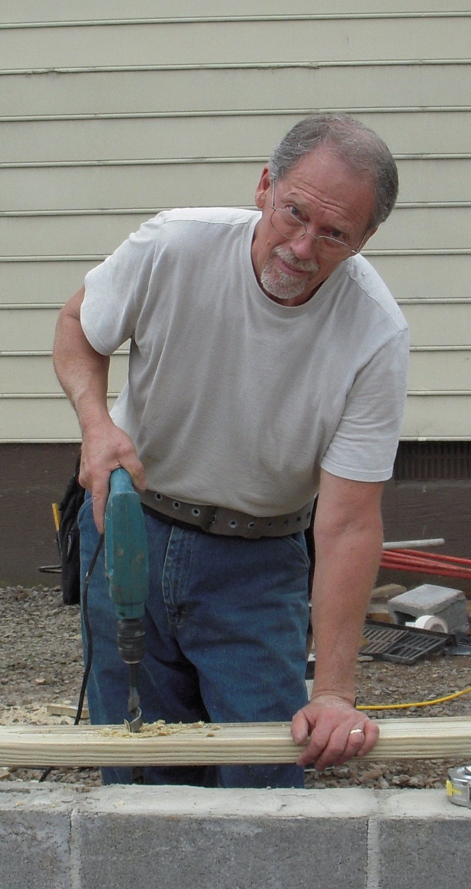 Norm's handyman at work with a drill on a project outdoors