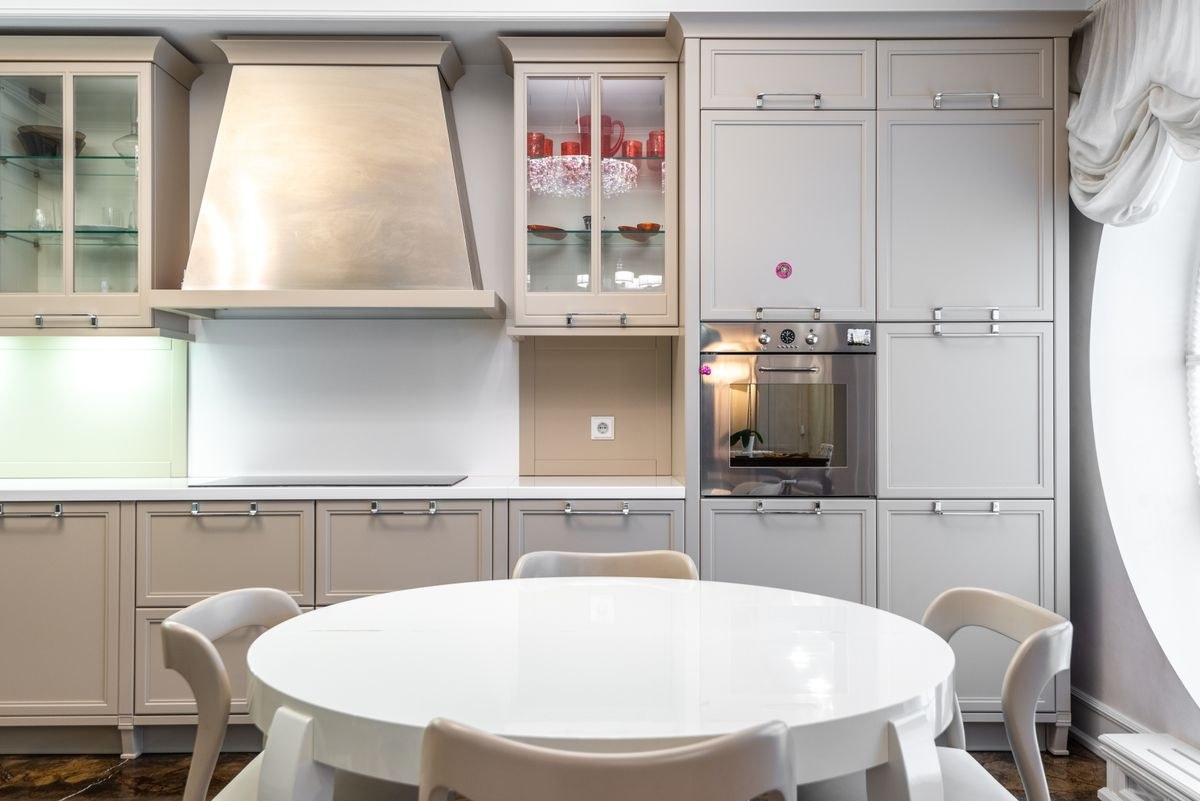 Bright finished kitchen with white cabinets and a dining table
