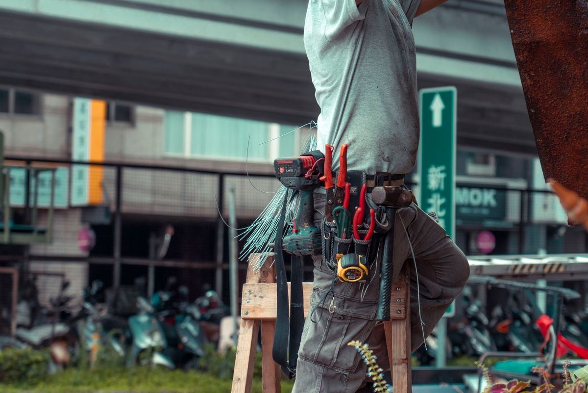 Handyman on a ladder with a full tool belt