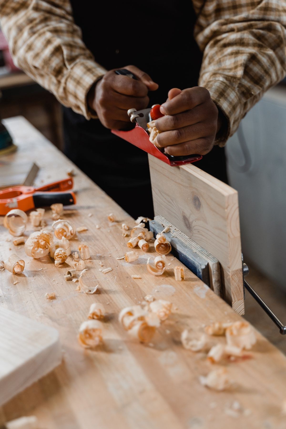 Hands planing a board in a carpentry workshop