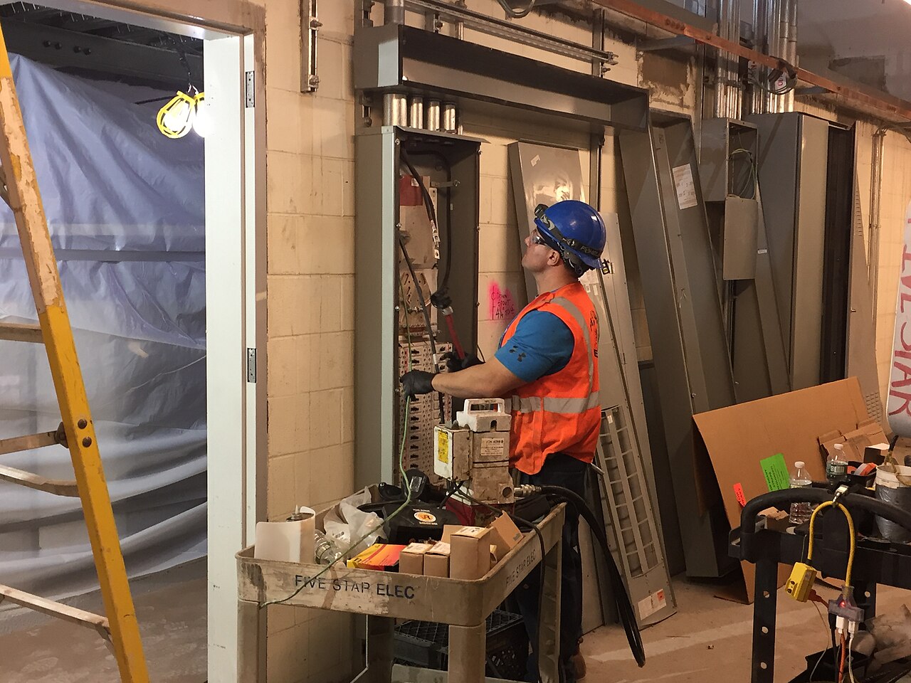 Electrician working on a large electrical panel