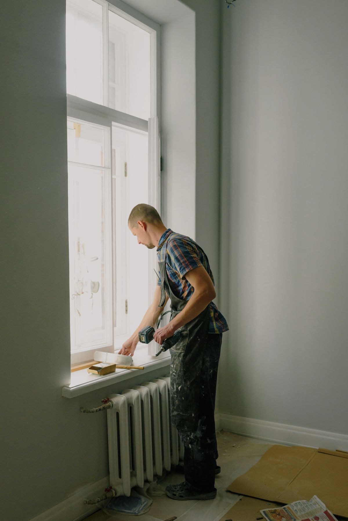 House painter working by a window inside a home