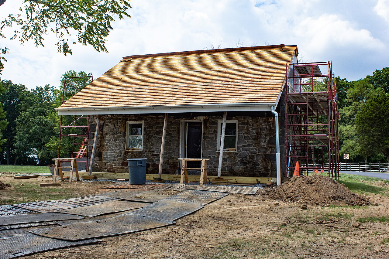 Stone house exterior under renovation with scaffolding